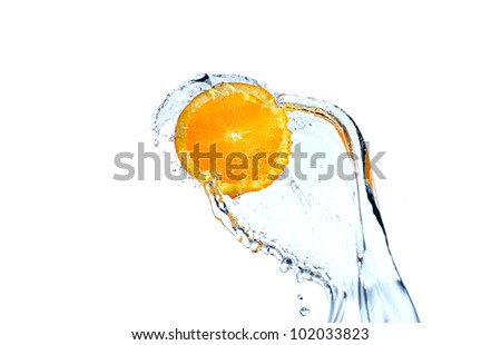Orange slice falling and splashing into clear water.