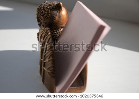 An owl statue, a stand for holding notes for notes