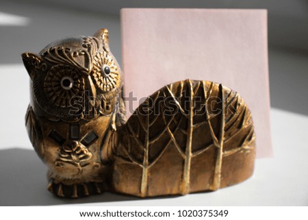 An owl statue, a stand for holding notes for notes
