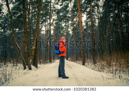 Image of man with backpack in winter forest