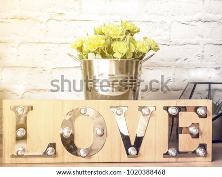 Love wood decorative sign and flower. Love or Valentine's concept. Soft shadow with natural light.