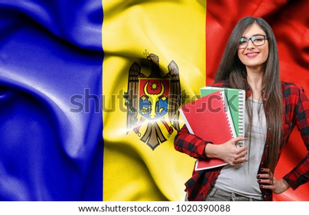 Happy female student holdimg books against national flag of Moldavia