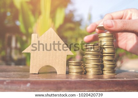 Paper cut of model house with coins on wooden table, Save money for prepare in the future. Concepts saving money for House.