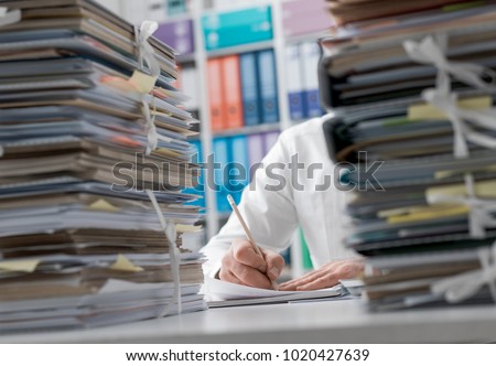 Business executive working in the office and piles of paperwork, he is overloaded with work Royalty-Free Stock Photo #1020427639