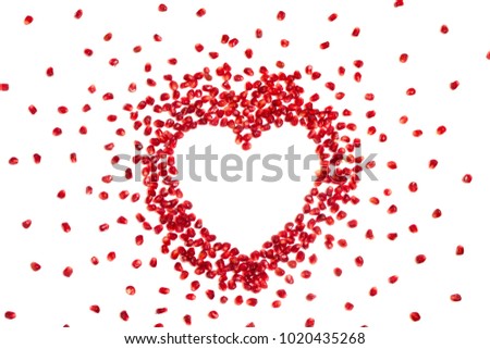Pomegranate seeds in heart shape, white background, copyspace