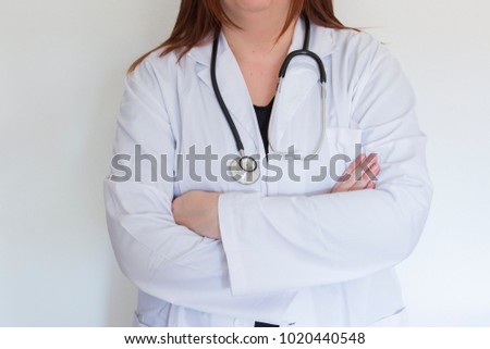 Portrait of young medical doctor over white background. stethoscope having over her neck. Indoors
