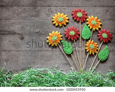 Group of gingerbread flowers and leafs on rustic wooden background. Spring, garden or gift concept.