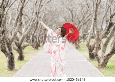 portrait of asian woman wearing kimono holding traditional red umbrella