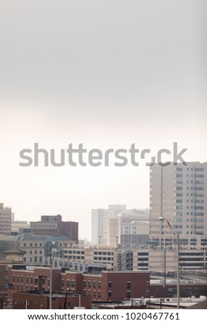 Cityscape scene with low hanging clouds taken in portrait orientation