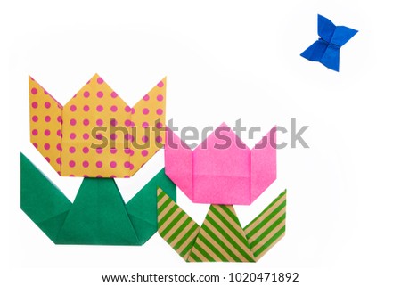 Origami for kids : colorful tulip flower and one butterfly with folded paper on white background isolated. Copy space for text.Top view, flat lay.Easy to use for card.