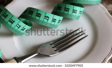 Conceptual picture of dieting with plate, fork and tape measuring, health