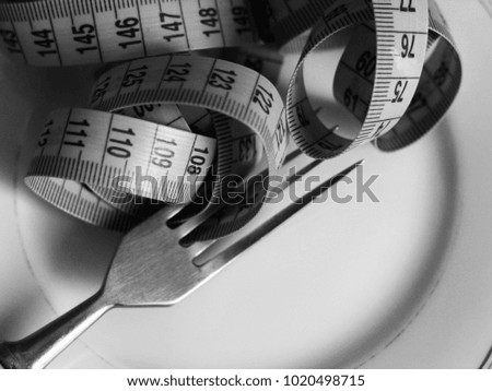Conceptual picture of dieting with plate, fork and tape measuring, health