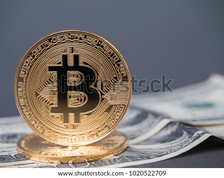 Golden bitcoins on the background of dollar bills