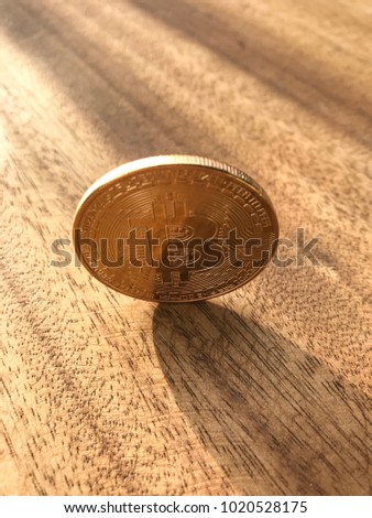 Bitcoin. Physical bit coin. Digital currency. Cryptocurrency. Golden coin with bitcoin symbol isolated on wooden background.