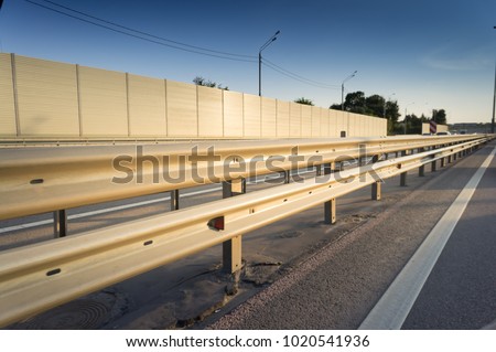 Safety rail on freeway with accoustic barrier Royalty-Free Stock Photo #1020541936