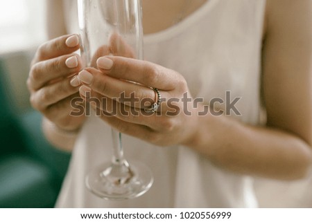 Wedding concept -bride holding beautifully decorated wedding glasses with wine. Wedding dress. Close up picture