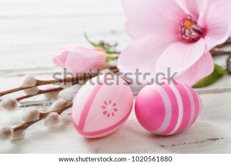 Pink easter eggs on a wooden background with a magnolia