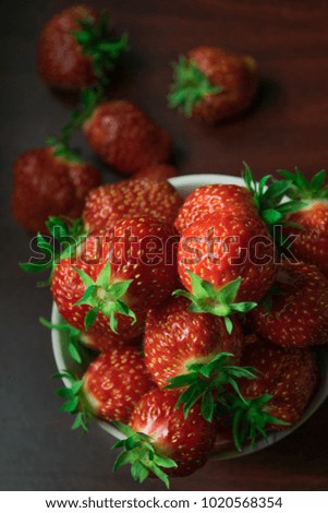 Fresh red strawberry close-up on a dark-brown wooden background