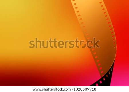Camera negative film. Selective focus on film perforation. Unprocessed color motion picture film. Industry symbol for shooting process, photochemical laboratory process and film archive technology. 