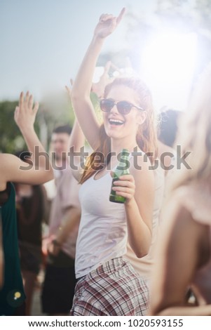 Ginger girl dancing, drinking an having a good time at outdoor party 