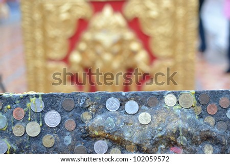Thai coins on the temple wall chiangmai, Thailand.