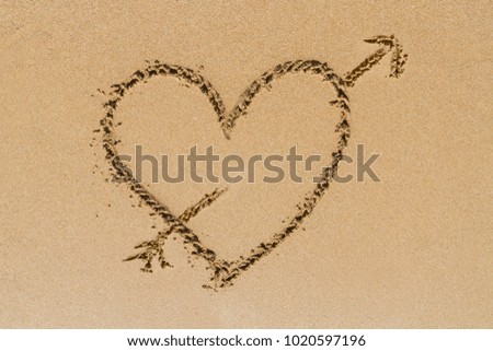 Sign of love heart shape on sand.