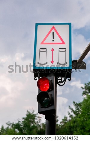 Traffic light with warning sign - Attention automatic retractable electric bollard metallic.
