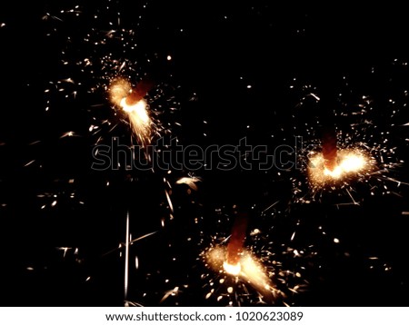 Christmas Bengal lights with bright sparks on a black background closeup