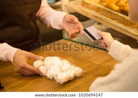 Cropepd shot of a little girl paying with a credit card for a pack of cookies at the store groceries food dessert eating payment consumtions customer consumerism banking children kids lifestyle.