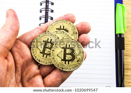 Golden Bitcoin in a man's hand .Symbol of a new virtual currency .