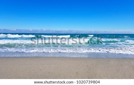Wave on sand beach on a sunny summer day 