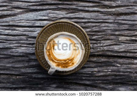 Hot latte art coffee on bark wood table background topview