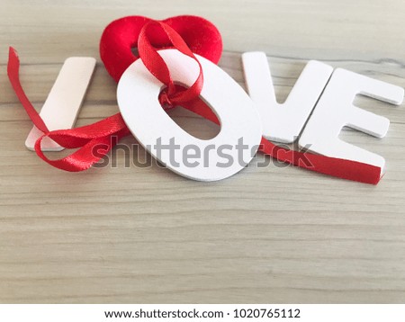 word Love from wooden letters on a wood background and valentines  red heart 