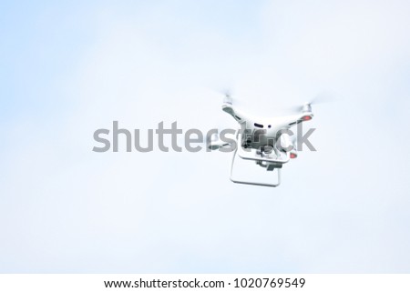 White drone flying on blue sky background