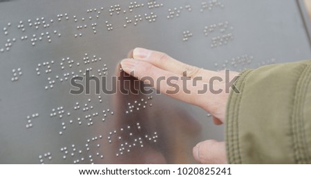 Blind reading on Braille at outdoor directory 