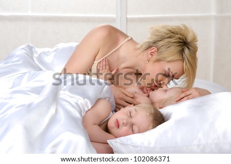 Happy family sleeping together on bed at home
