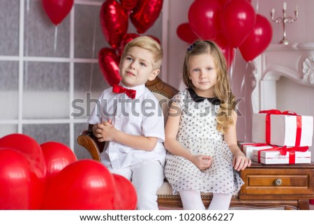 A boy with a girl with gifts on the background of hearts. Valentine's Day.