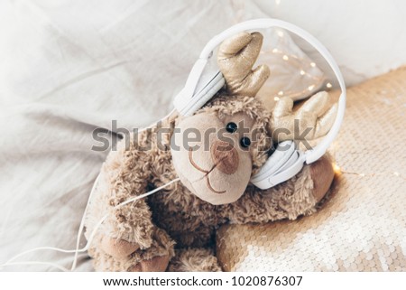 Brown toy with headphones. Cute fun pictures. Listening music