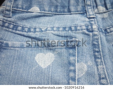 Heart shape on a back pocket of a navy blue denim jeans, Denim jeans texture, denim jeans background with a seam. Jeans fashion design with copy space, romantic love concept,valentines day concept.