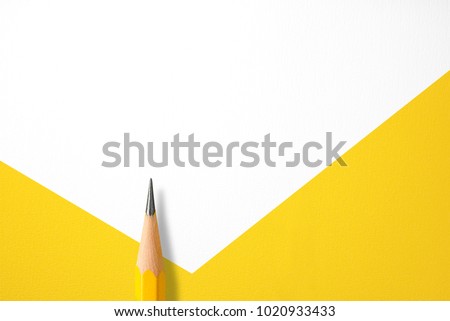 Minimalist template with copy space by top view close up macro photo of wooden yellow pencil isolated on white texture paper and combine with yellow shape. Flash light made smooth shadow from pencil.