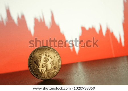 Bitcoin gold coin on the background of the graph of the monitor. Business concept