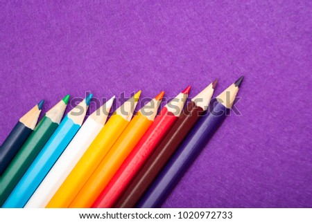 Nine multicolored pencils on a purple felt background. Different colored pencils with space for text. Back to school. Art lessons. Royalty-Free Stock Photo #1020972733