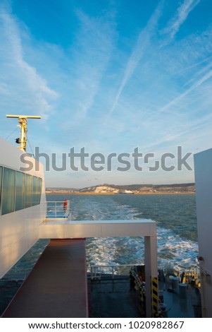 Early morning spring sunshine as a cross channel ferry departs the Port of Dover, Kent, UK heading for Calais, France