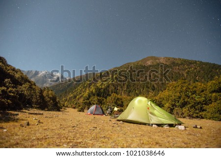 Tents and bicycles at night  with moon light in the Himalayas,  Tibet region of China at autumn time 