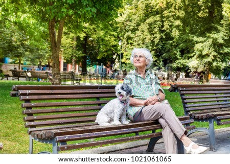 Beautiful Senior Woman Hugging her Cute Dog in the Park