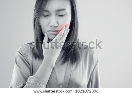 Asian women in nightwear and robe suffering from toothache while standing against grey background, Tooth Pain And Dentistry, Dental Care And Health Concept Royalty-Free Stock Photo #1021072396