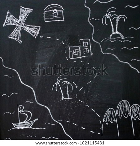 A treasure map is drawn with chalk on a black board.