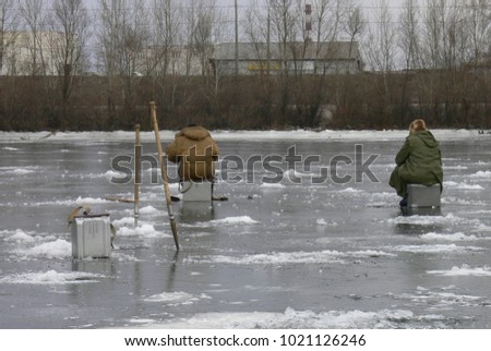 fishermen fishing on a frozen lake