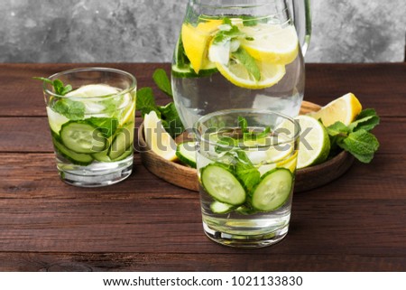 Detox drink with cucumber, lemon and mint in glasses on a wooden background