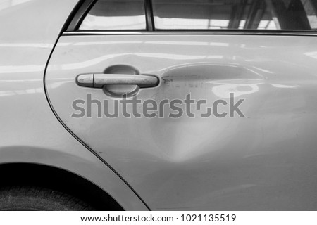 The dents on the car door caused by the accident Royalty-Free Stock Photo #1021135519